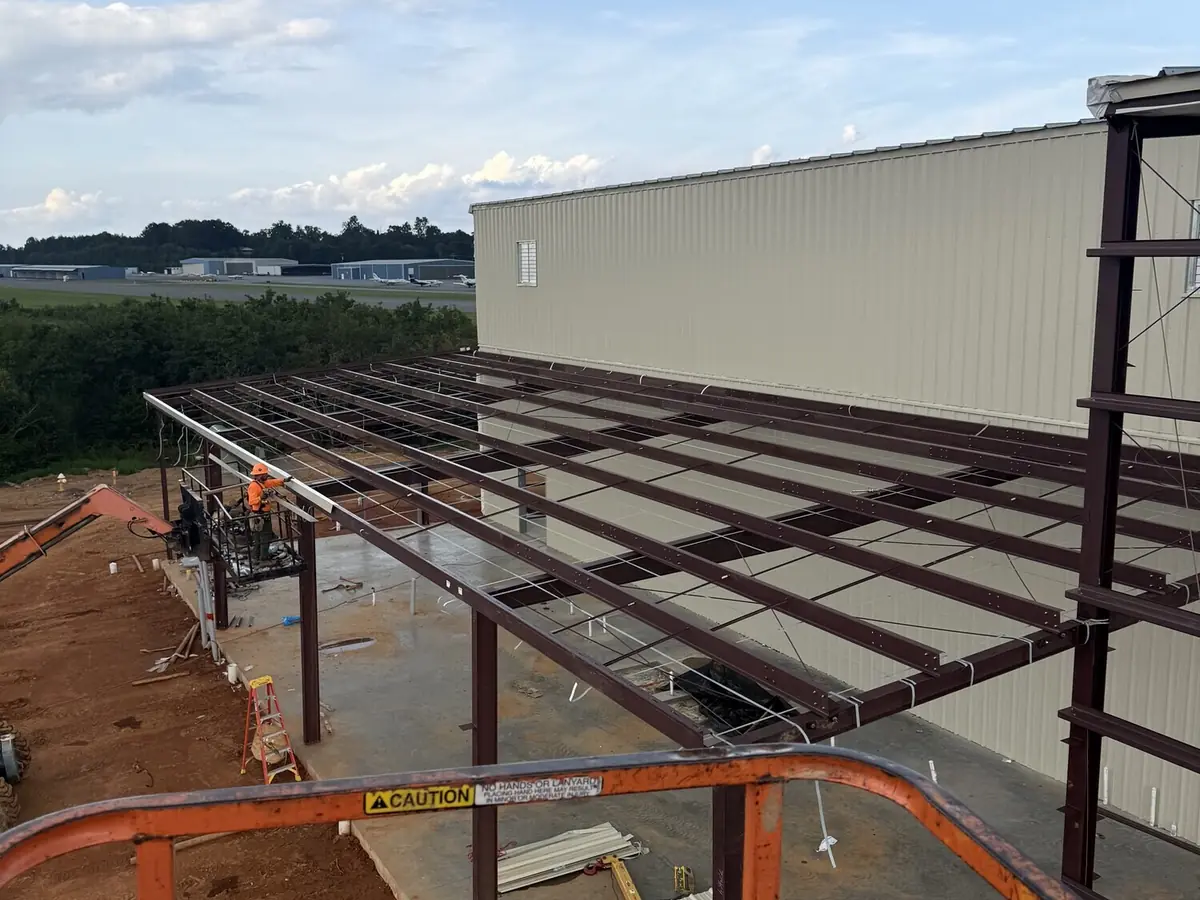 Steel framing part-clad on a long metal building, seen from a lift